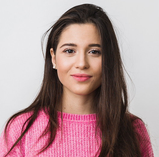 Portrait of a girl with dark hair in a pink sweater